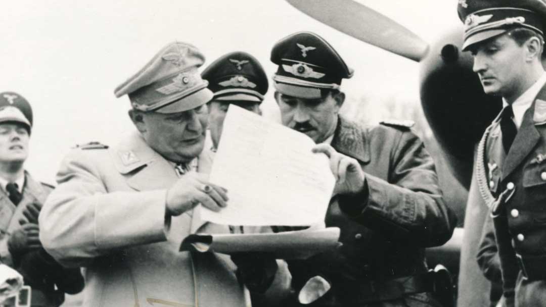 Adolf-Galland-reviewing-documents-with-Hermann-Goering-surrounded-by-other-Luftwaffe-officers