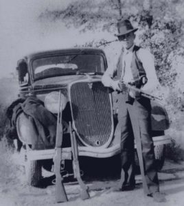 Clyde Barrow in front of a car