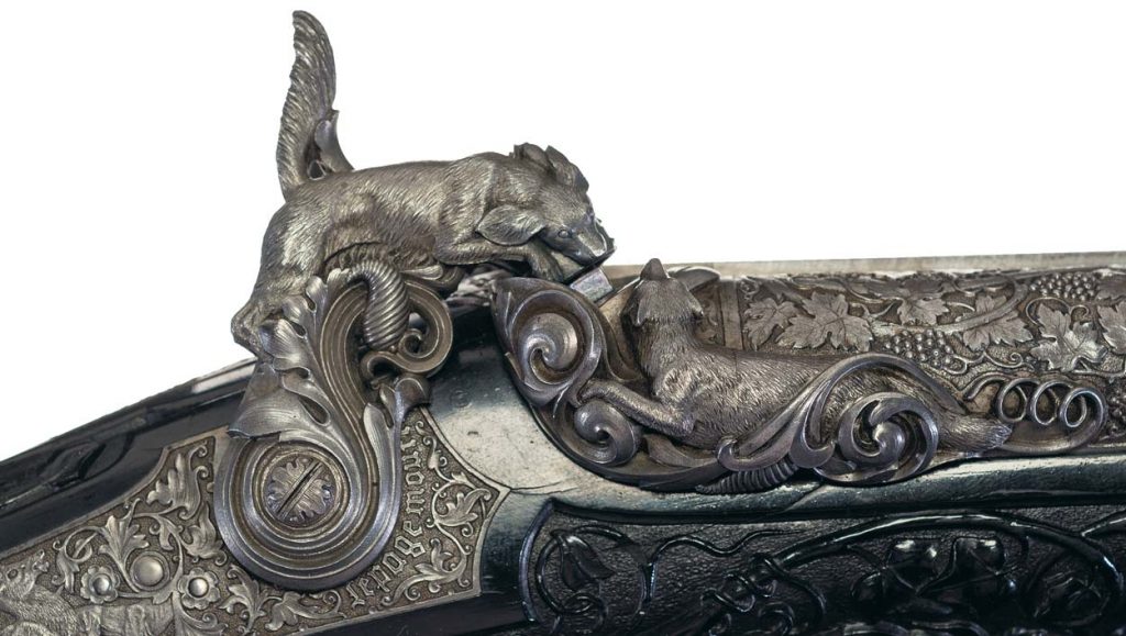 A close-up of the dog-shaped carved steel hammer, the percussion cap holder fox, and the breech.