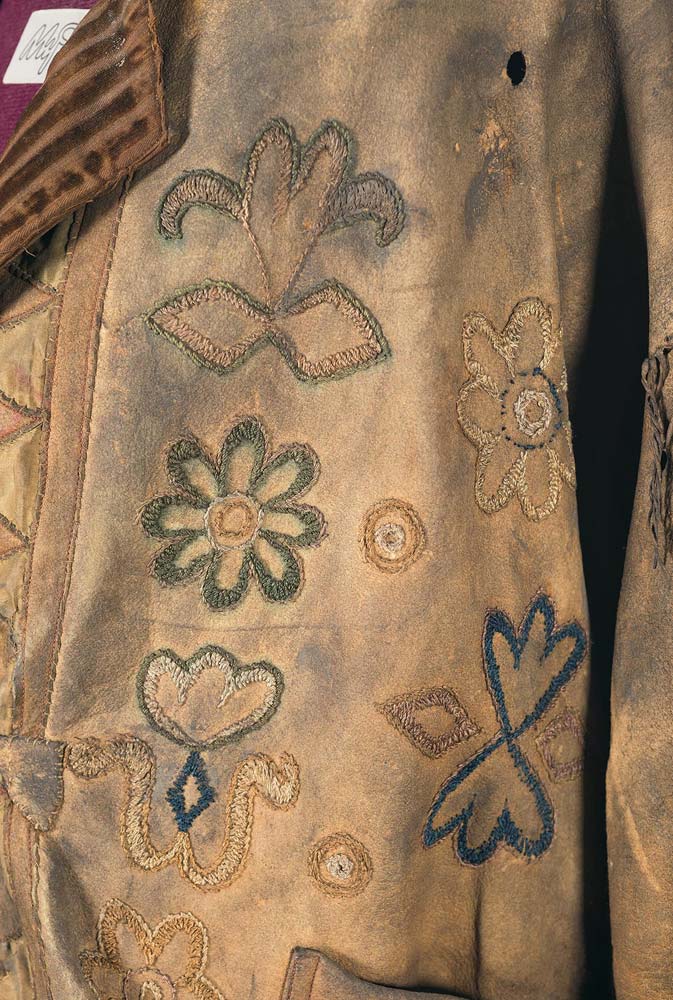 A close-up of the embroidery with a bullet hole visible in the upper right portion of the photo.